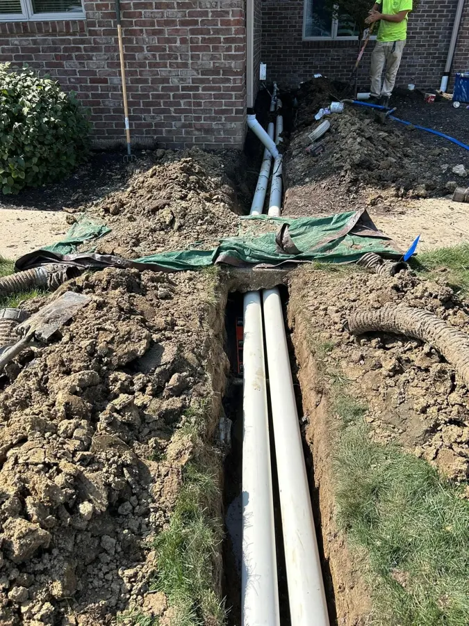 Sump pump and buried downspout drains installed for basement drainage
